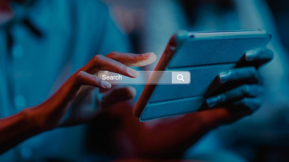 Expert en stratégie SEO à Lyon utilisant une tablette pour analyser des données de recherche.